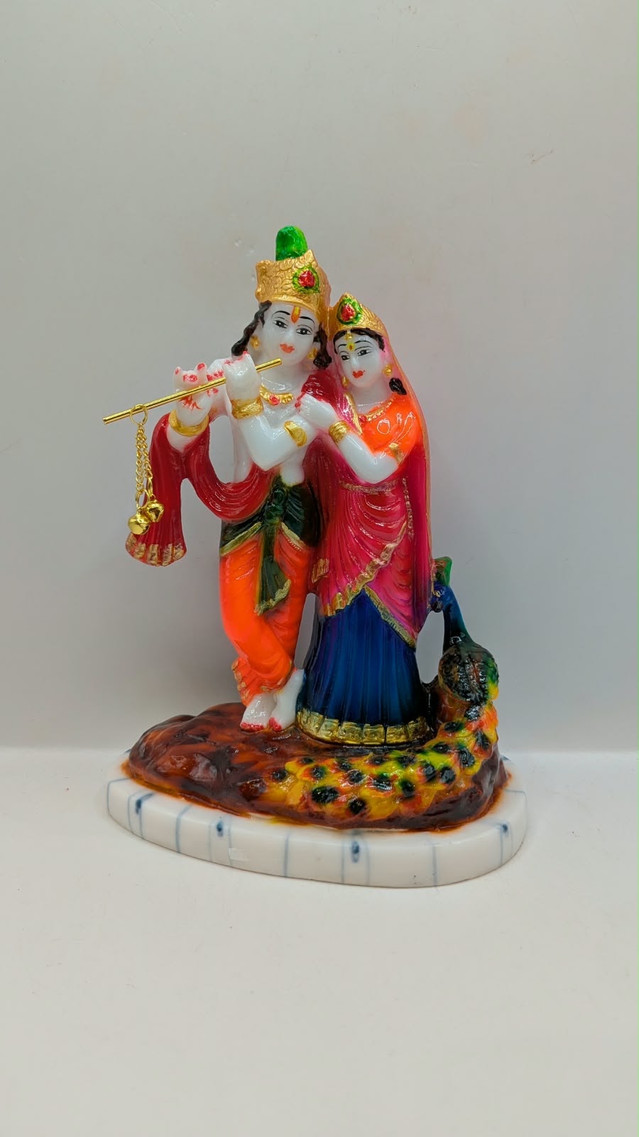 Colourful Radha Krishna statue with peacock, front view