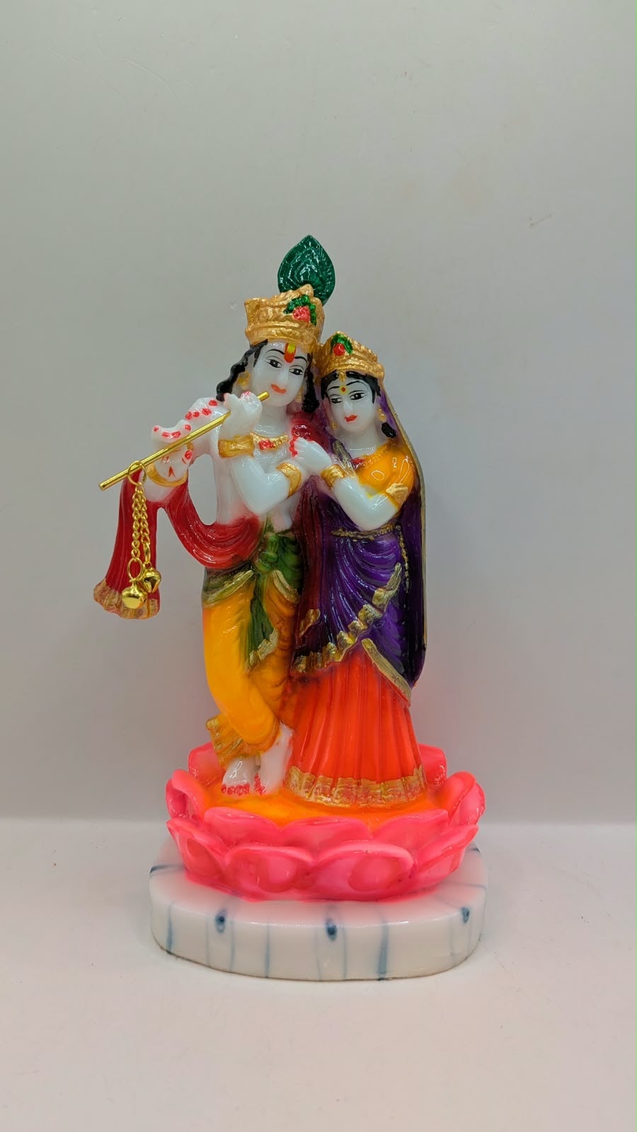 Colourful Radha Krishna statue on pink lotus, front view