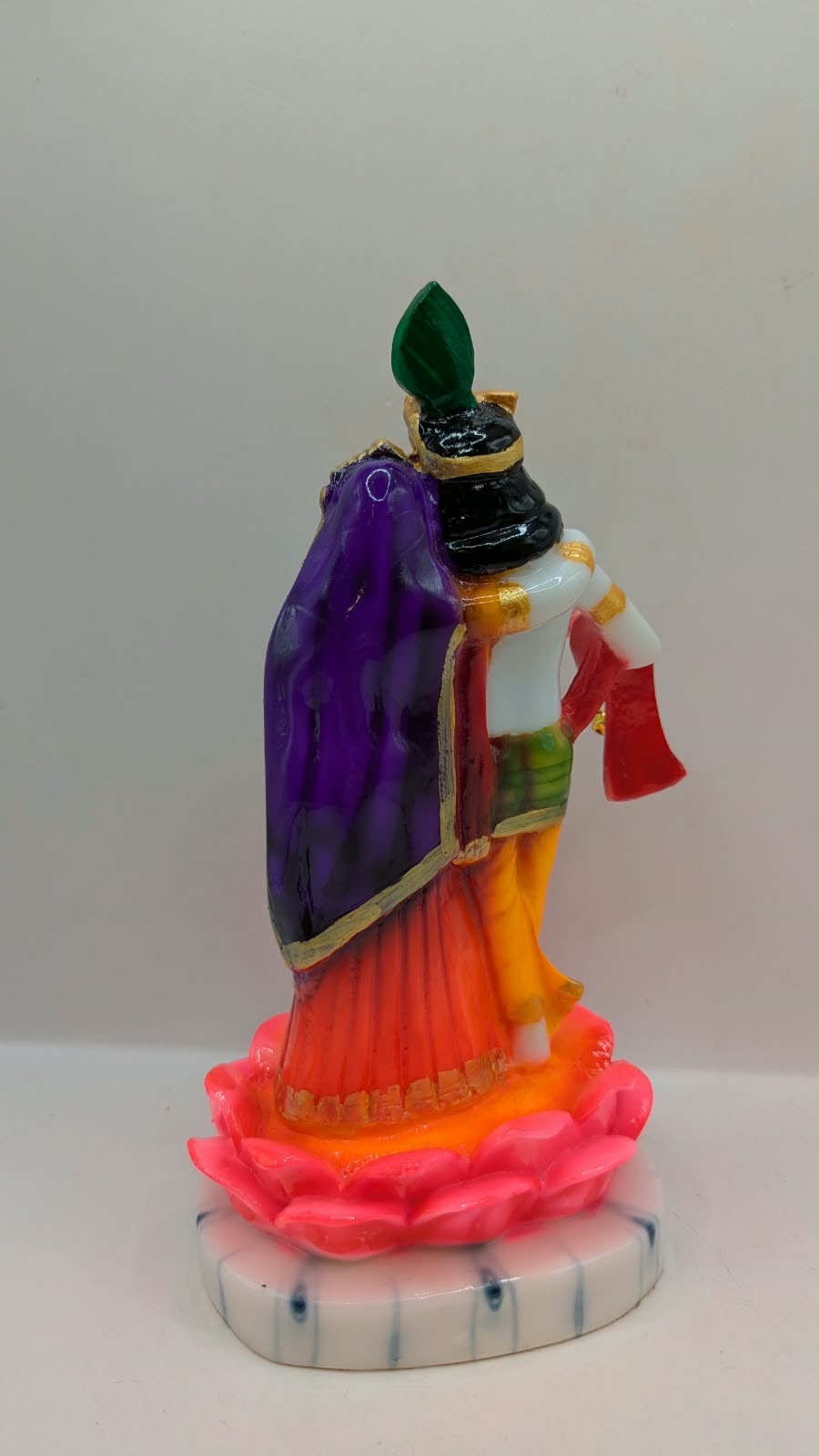 Colourful Radha Krishna statue on pink lotus, back view