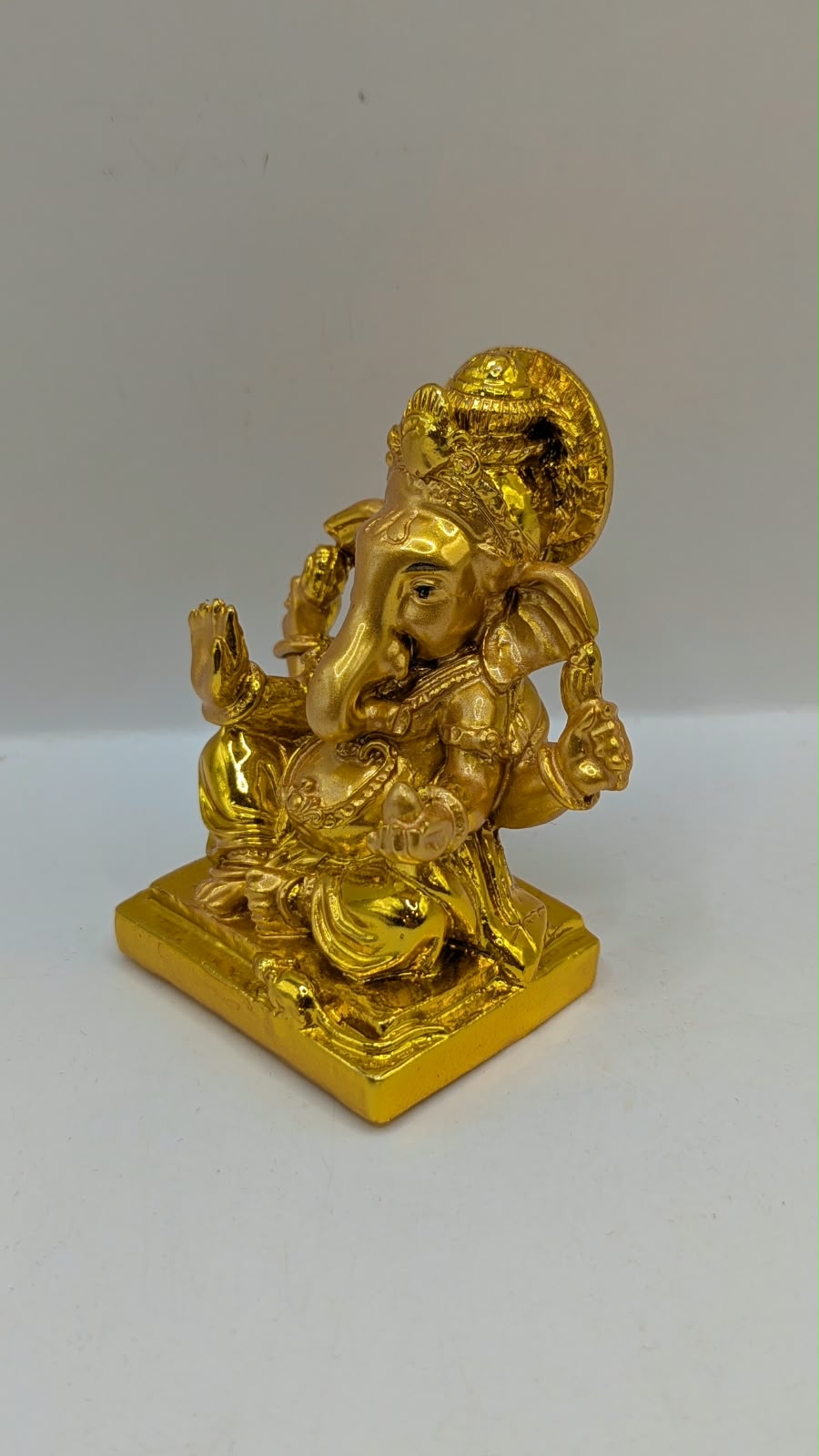 Gold Ganesh statue with round halo, other side view