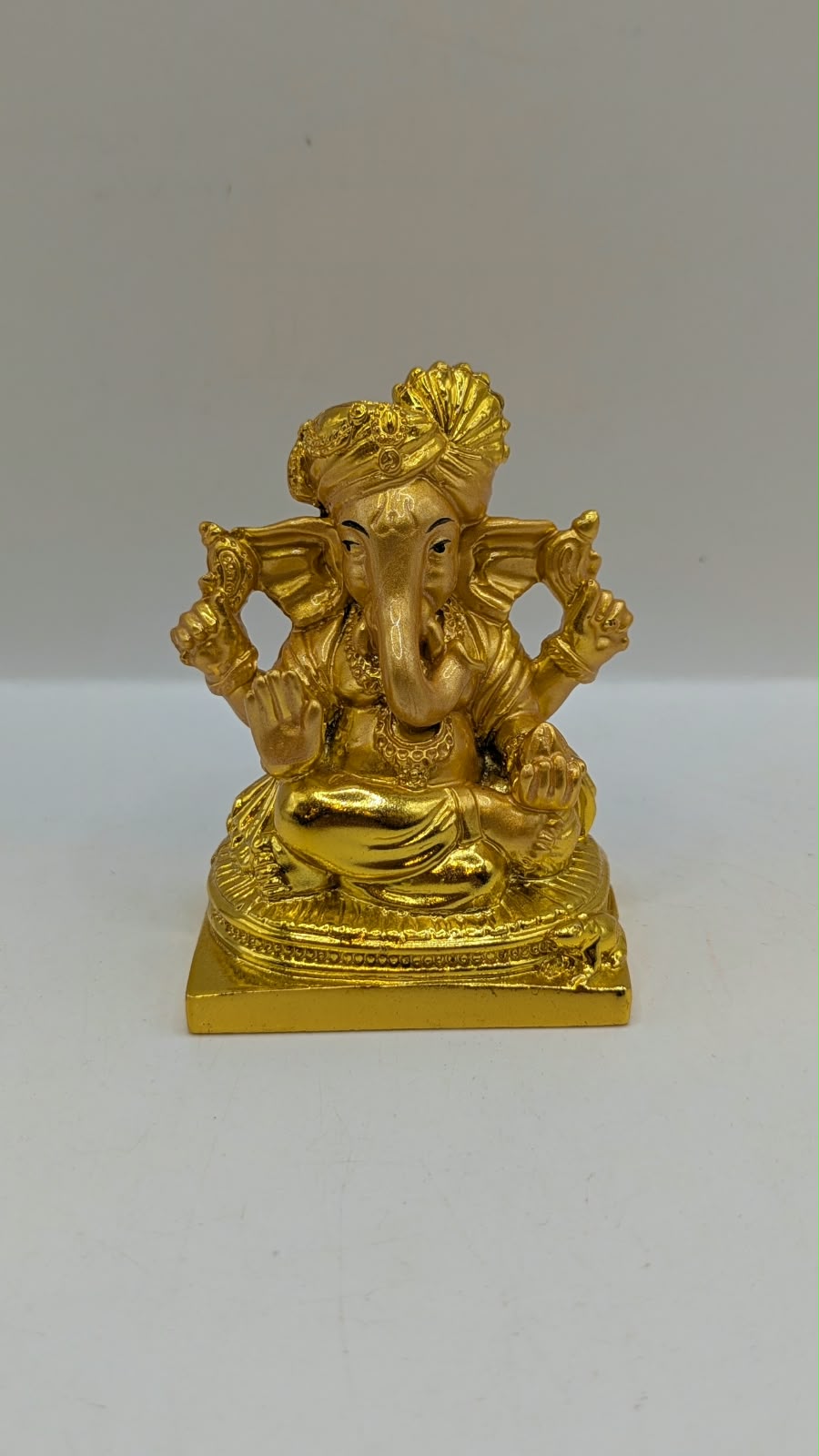 Gold Ganesh statue wearing a turban, front view