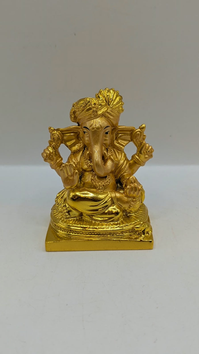 Gold Ganesh statue wearing a turban, front view