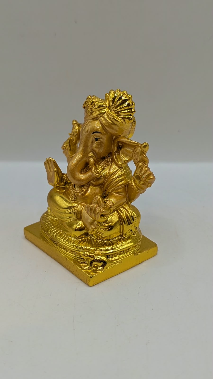 Gold Ganesh statue wearing a turban, other side view