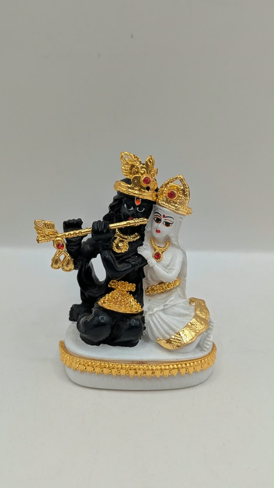Black and white Radha Krishna statue with gold, front view