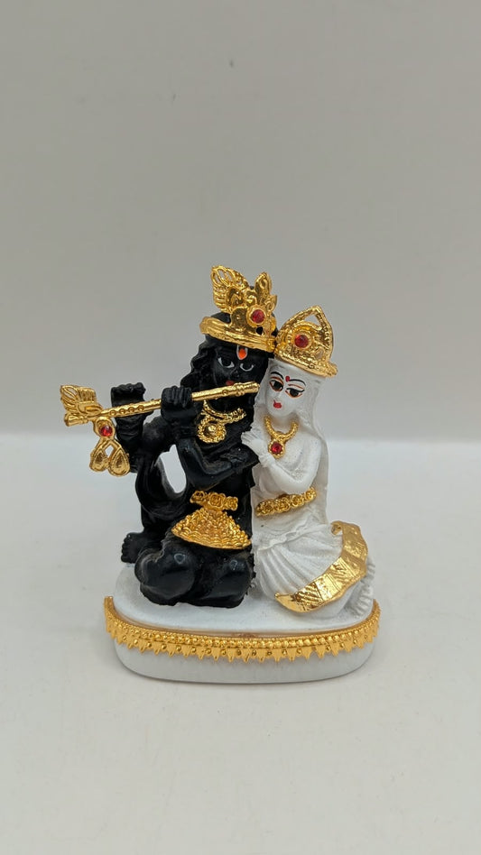 Black and white Radha Krishna statue with gold, front view