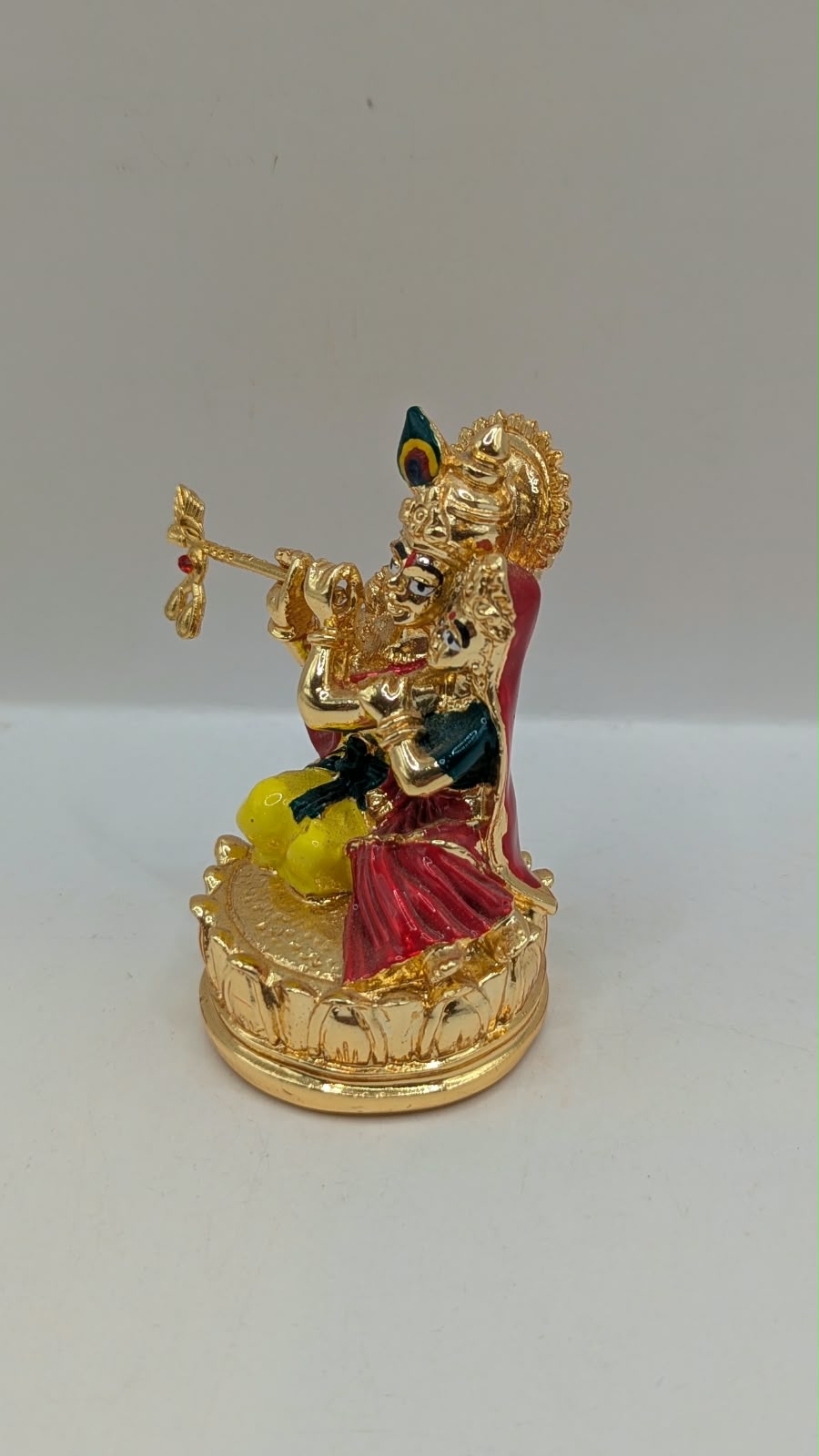 Gold Radha Krishna statue on a lotus base, other side view