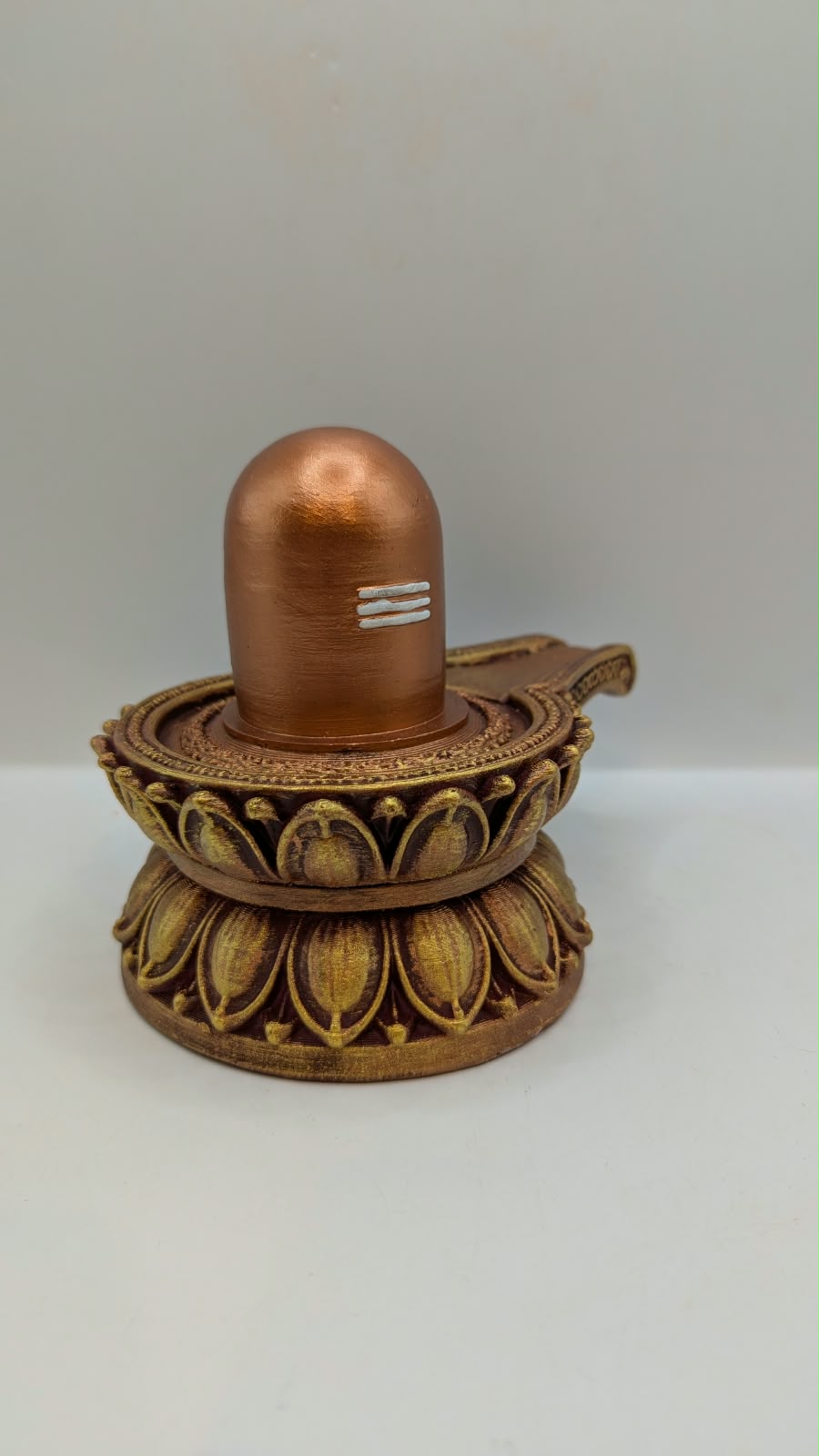 Copper and gold Shivling statue, side view