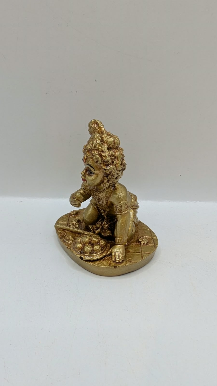 Gold crawling baby Krishna statue, other side view