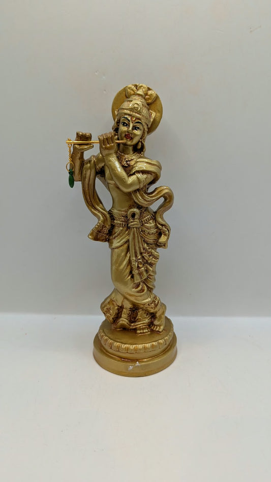 Gold Krishna statue with flute and halo, front view