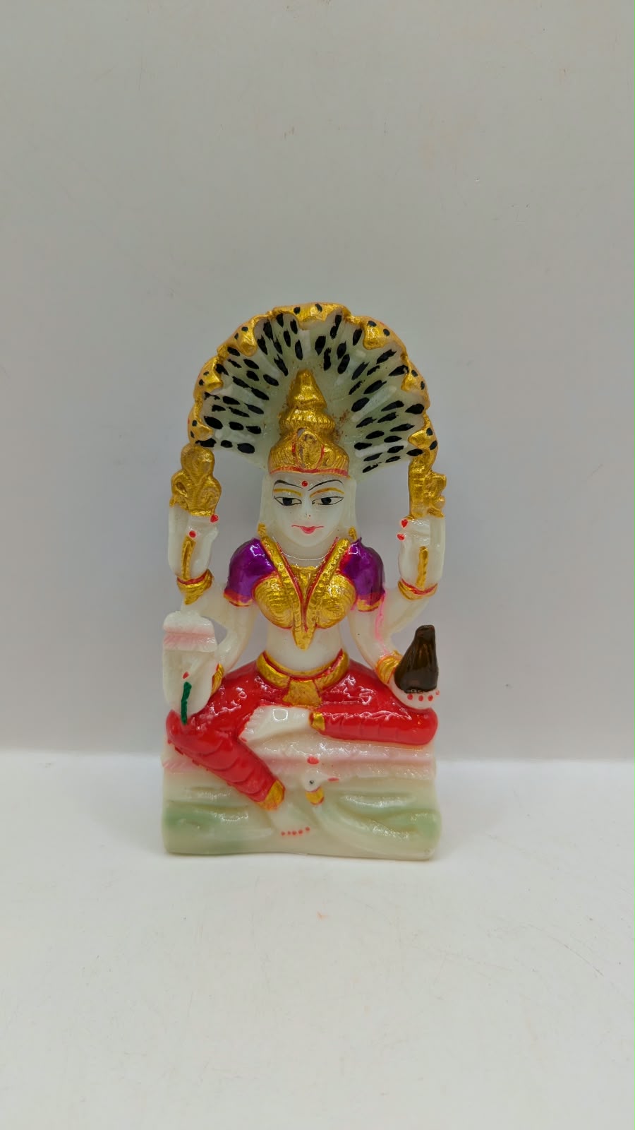 White Padmavati Devi statue with peacock arch, front view