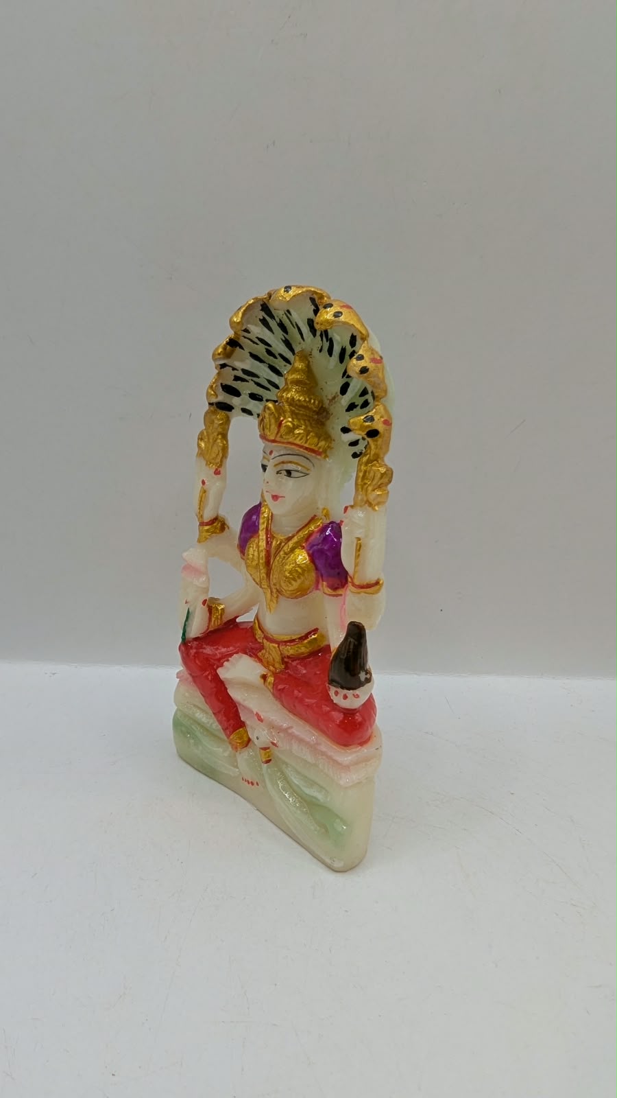 White Padmavati Devi statue with peacock arch, other side view