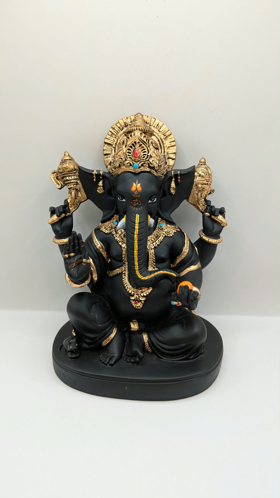 Black and gold Ganesh statue with big crown, front view
