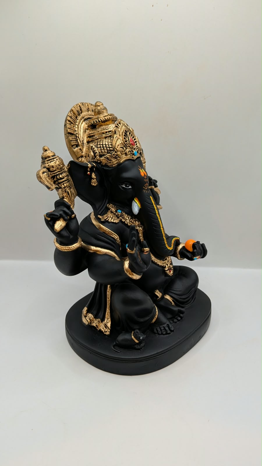 Black and gold Ganesh statue with big crown, side view