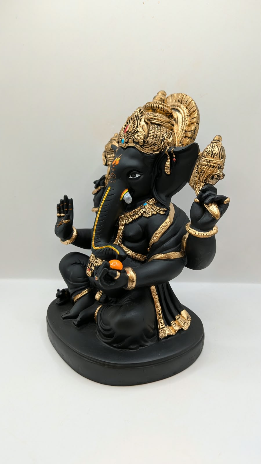 Black and gold Ganesh statue with big crown, other side view