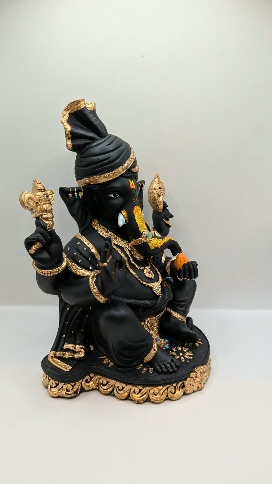 Black and gold Ganesh statue with turban, side view