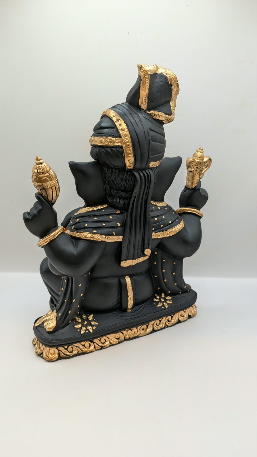 Black and gold Ganesh statue with turban, back view