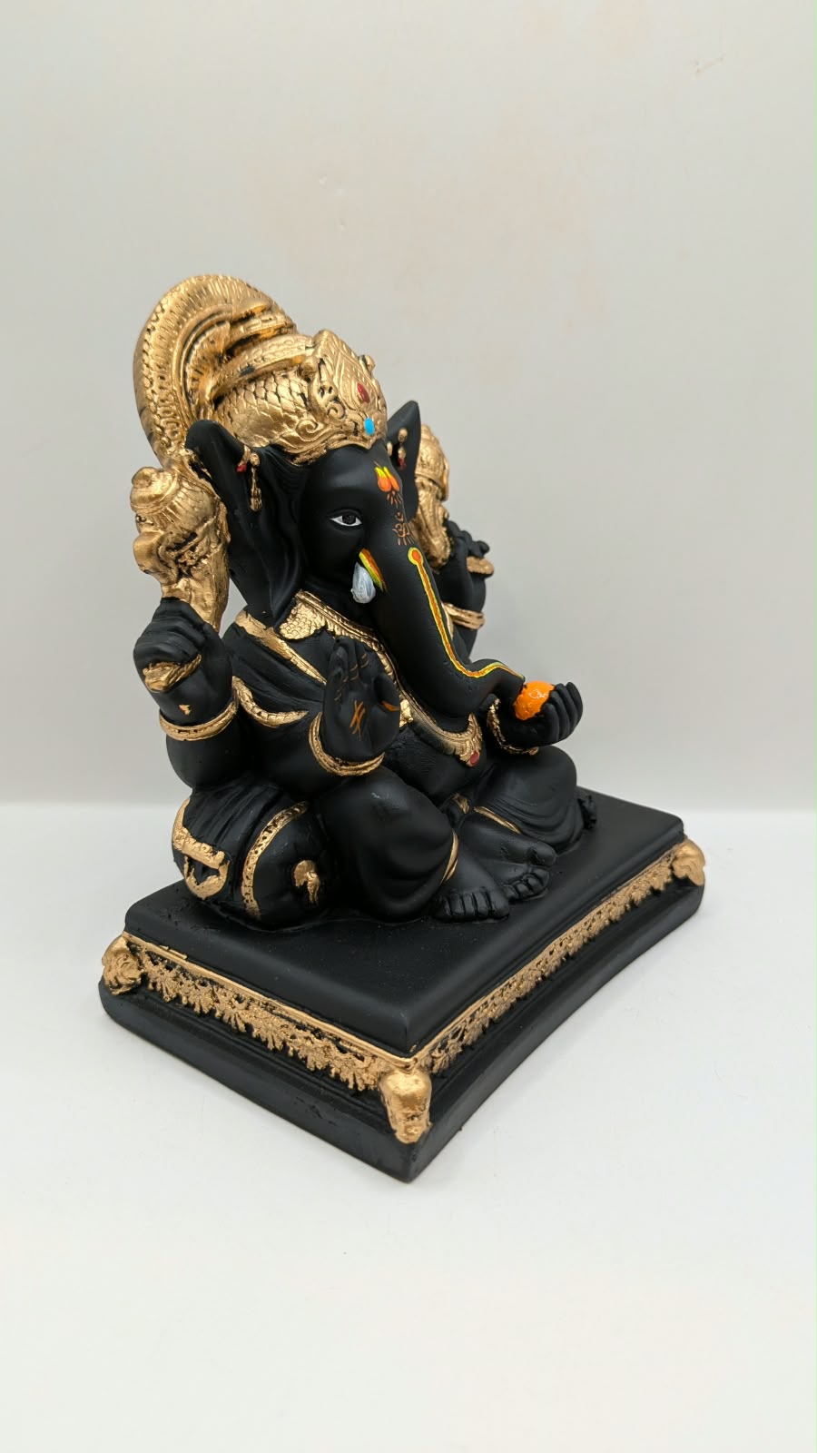 Black and gold Ganesh statue on throne base, side view