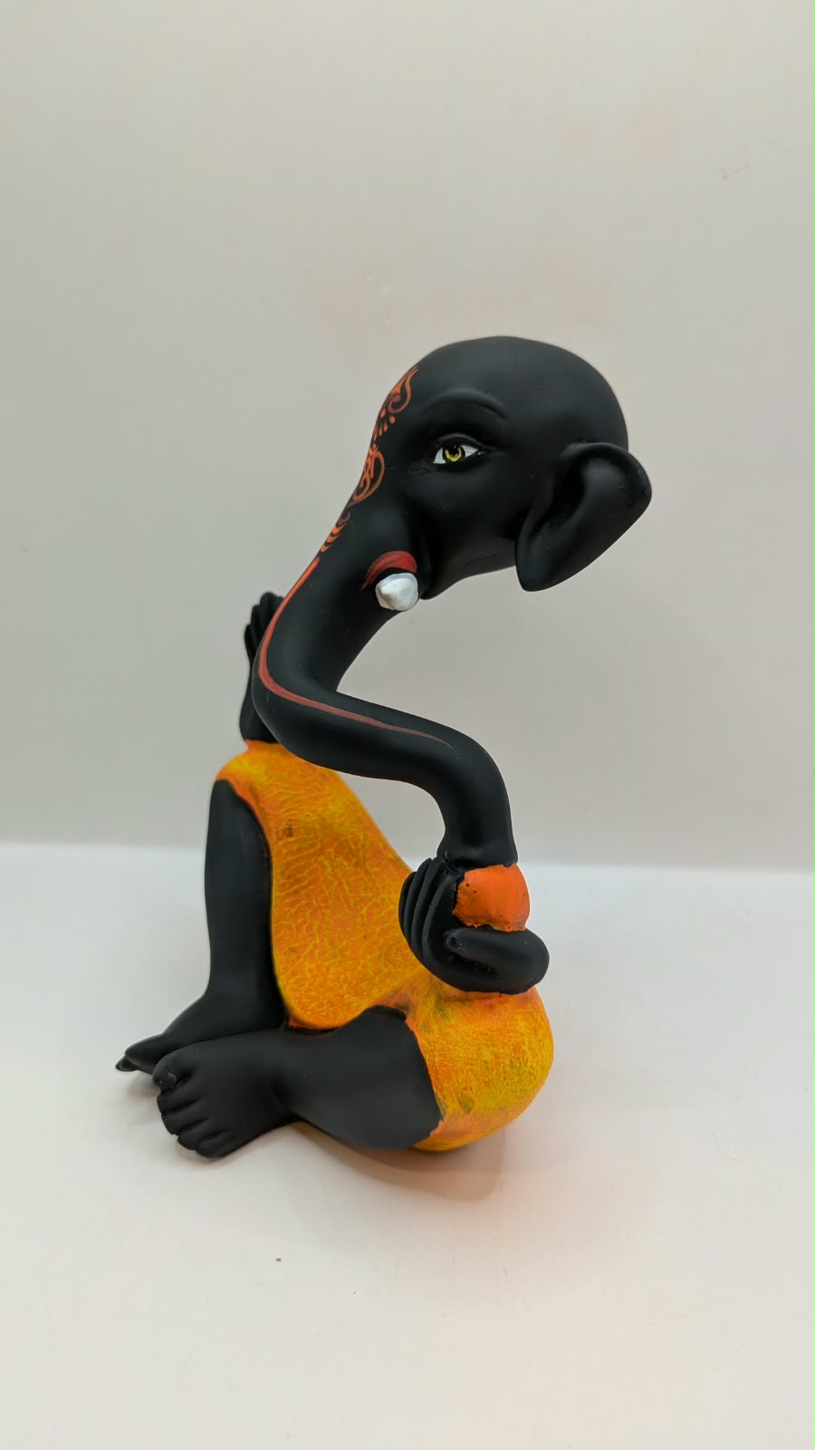 Modern black Ganesh statue with orange dhoti, other side view