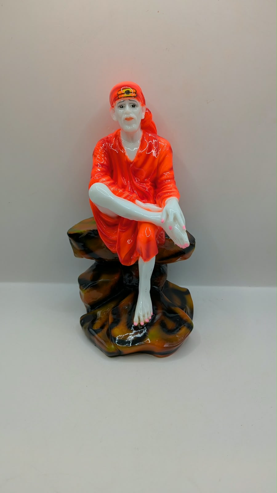 Sai Baba statue on rock seat, front view