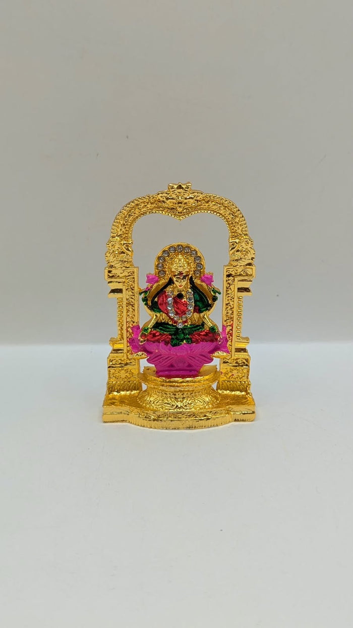 Gold Laxmi murti in temple arch on pink lotus, front view