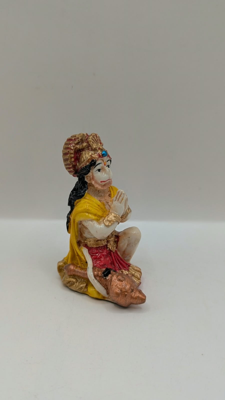Yellow and red praying Hanuman resin statue, side view