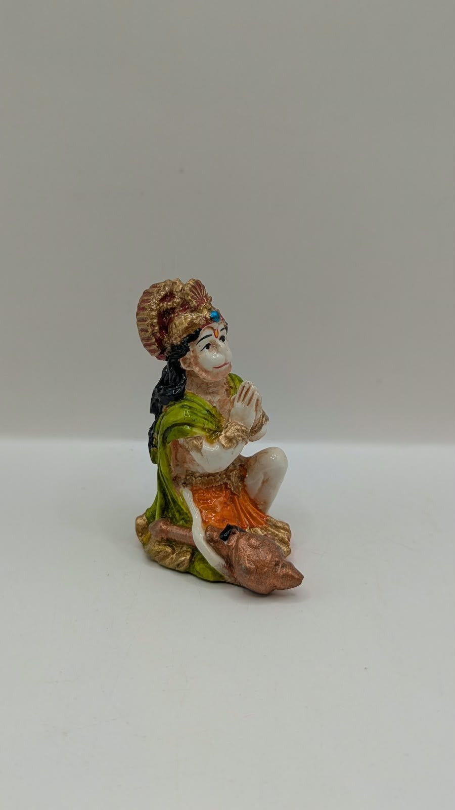 Green and orange praying Hanuman resin statue, side view