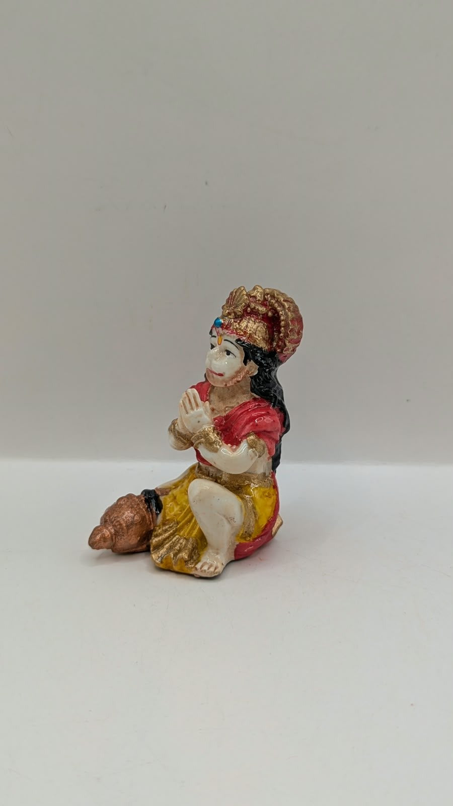Red and yellow praying Hanuman resin statue, other side view