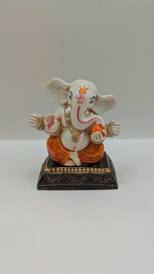 White and orange Ganesh resin statue, front view