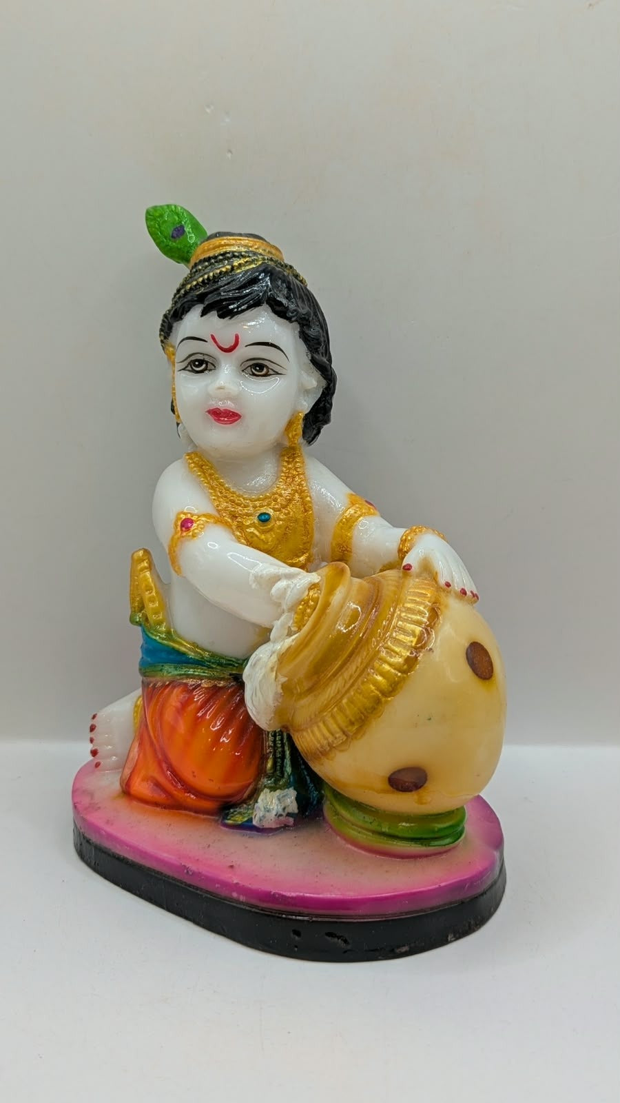 White baby Krishna statue kneeling with butter pot, other side view