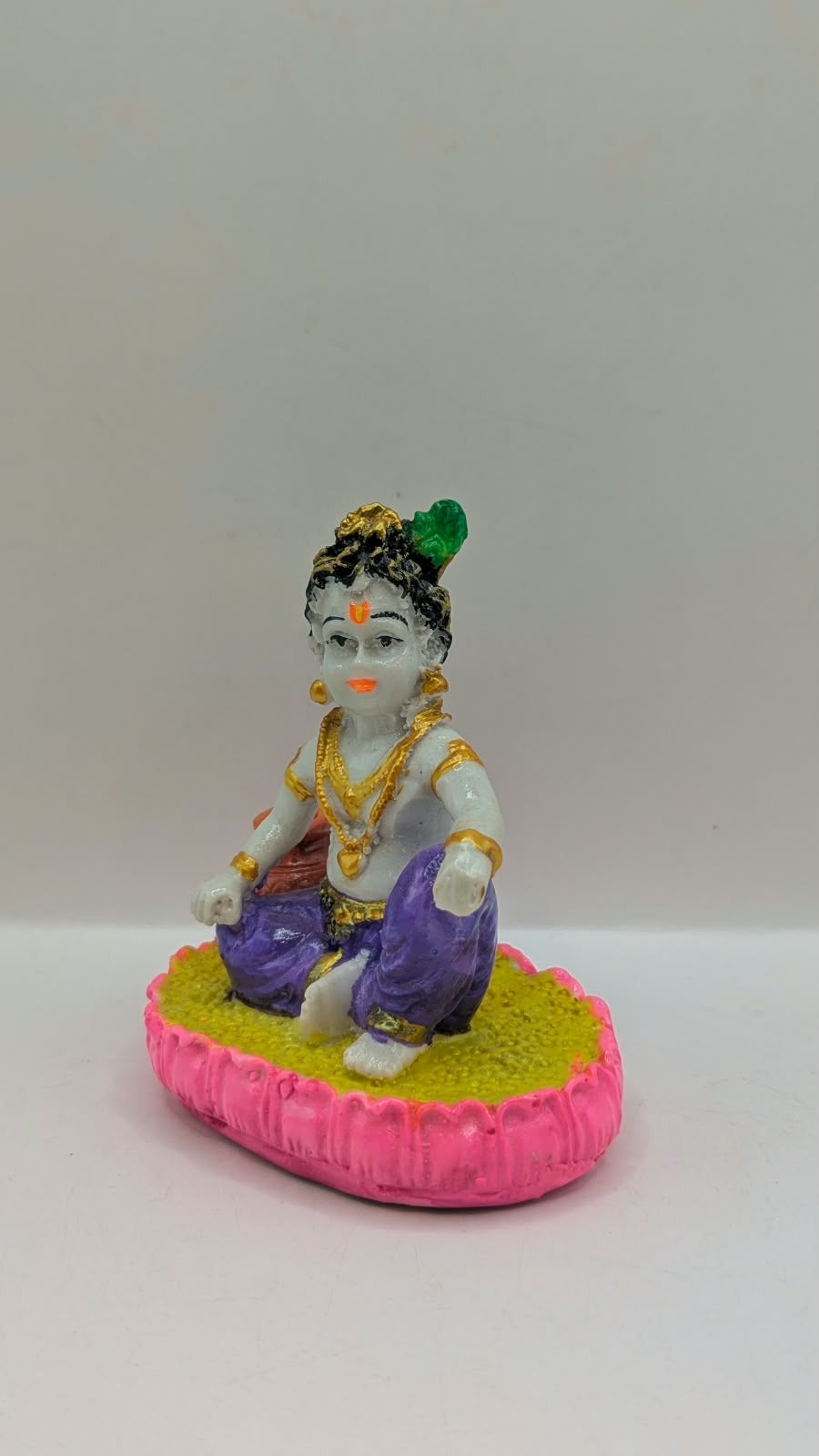 Baby Krishna statue in purple dhoti, front view