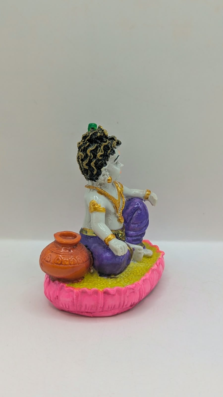 Baby Krishna statue in purple dhoti, other side view