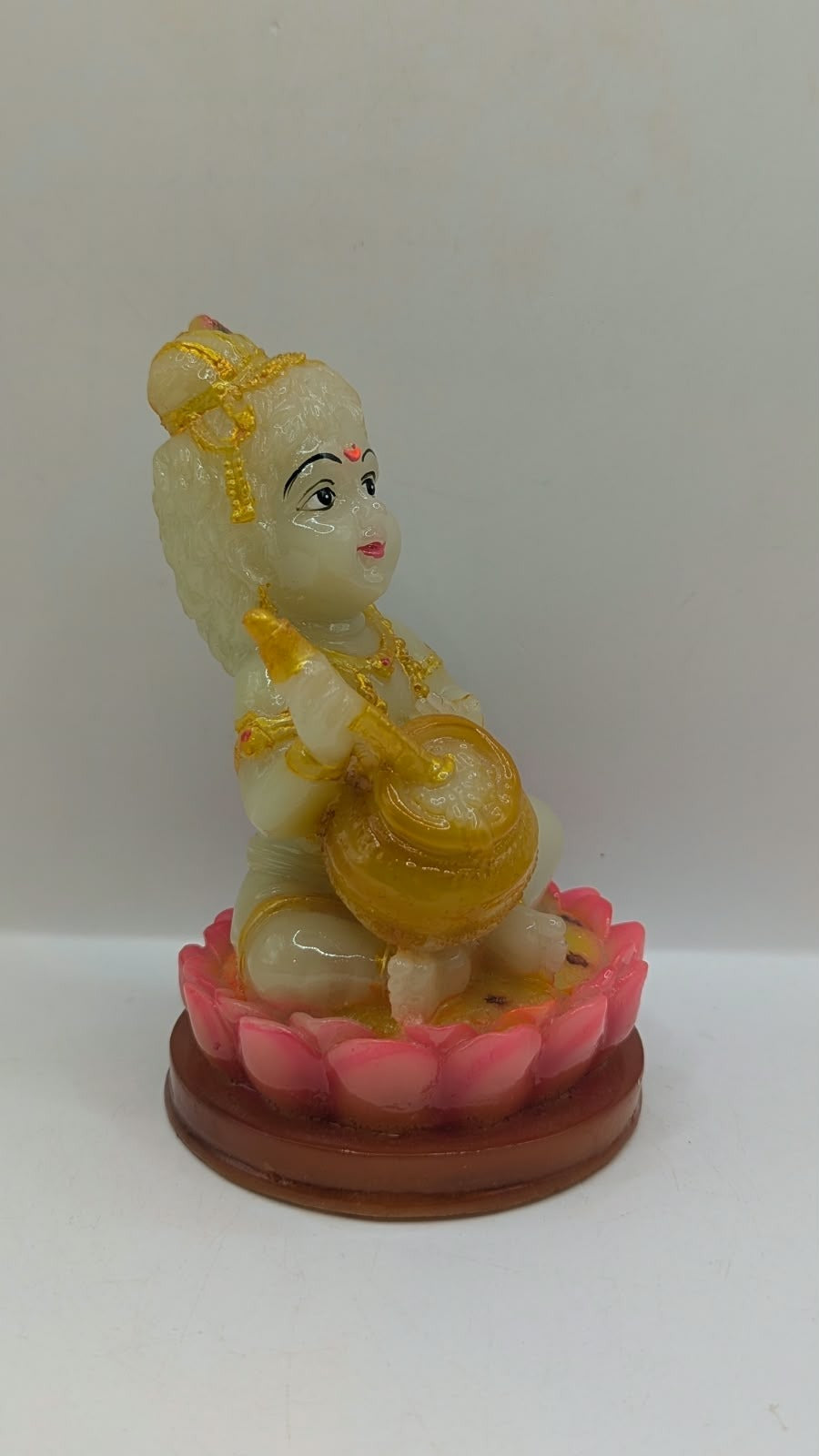 Cream and gold baby Krishna statue on lotus, other side view