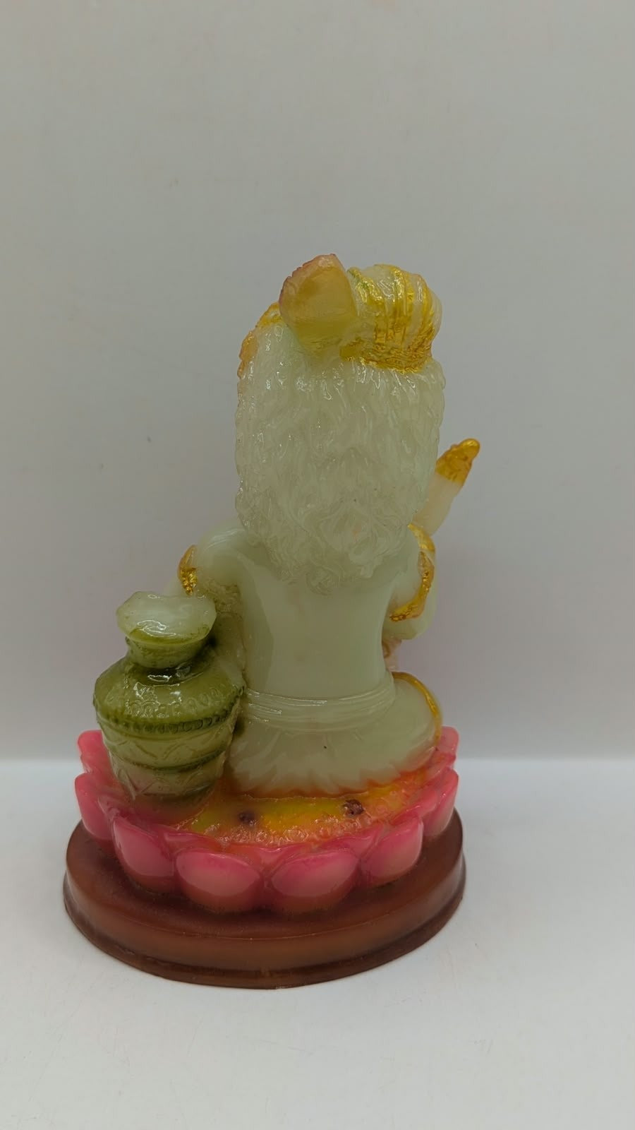 Cream and gold baby Krishna statue on lotus, back view