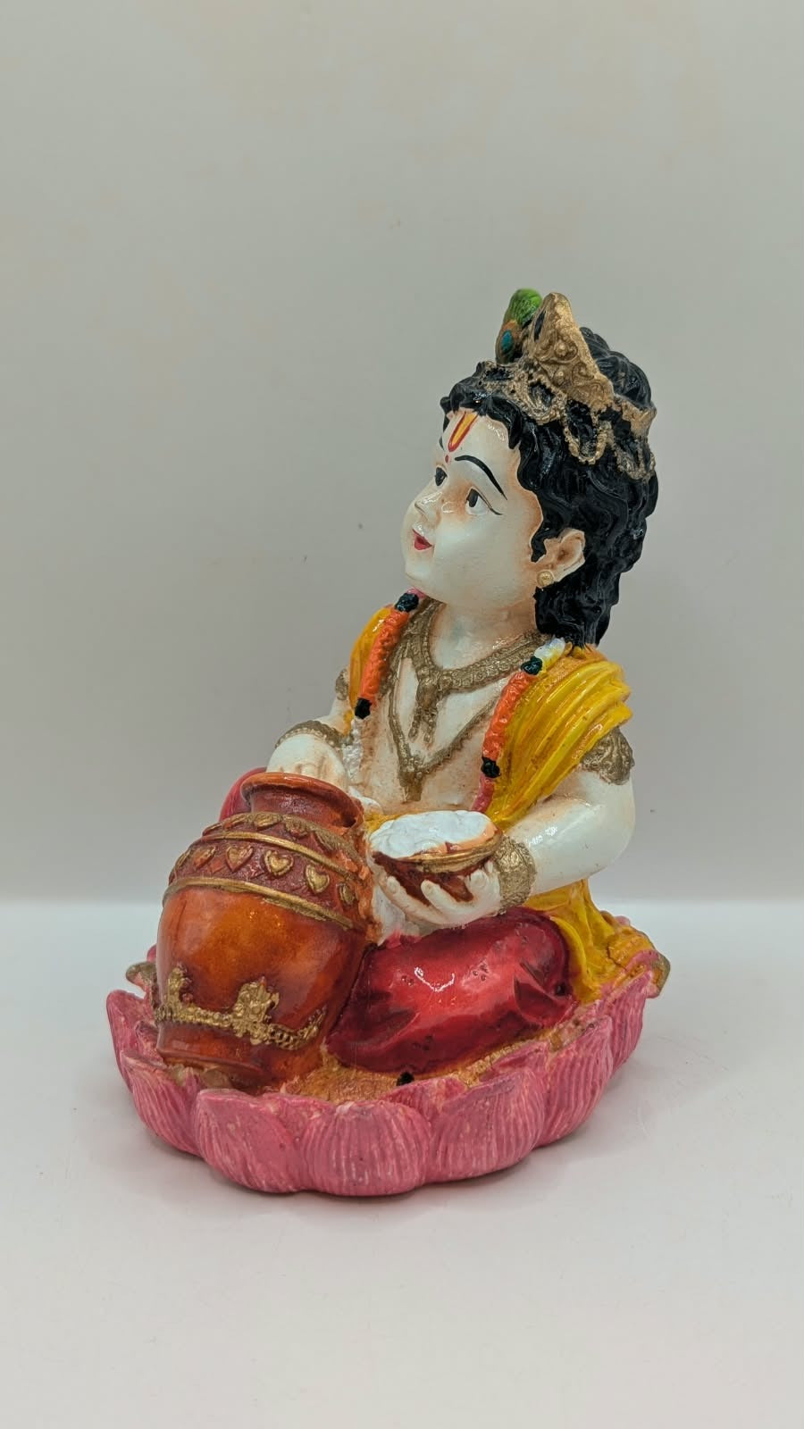 Baby Krishna statue in red dhoti on pink lotus, other side view