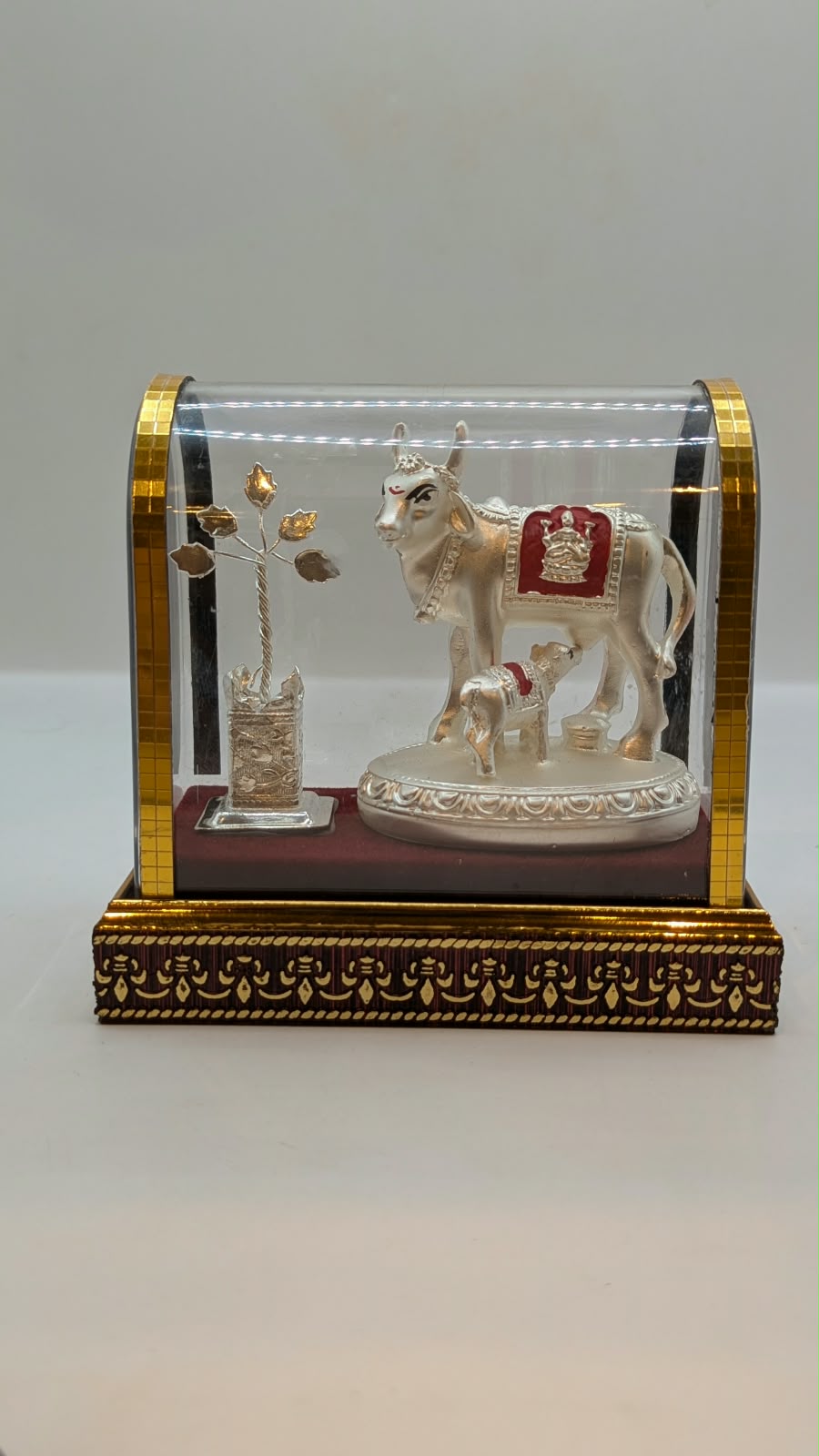 Silver Kamdhenu cow and calf in clear case, front view