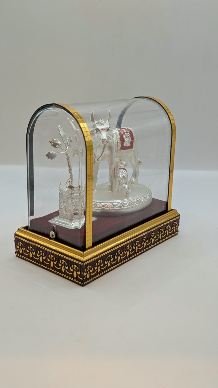 Silver Kamdhenu cow and calf in clear case, side view