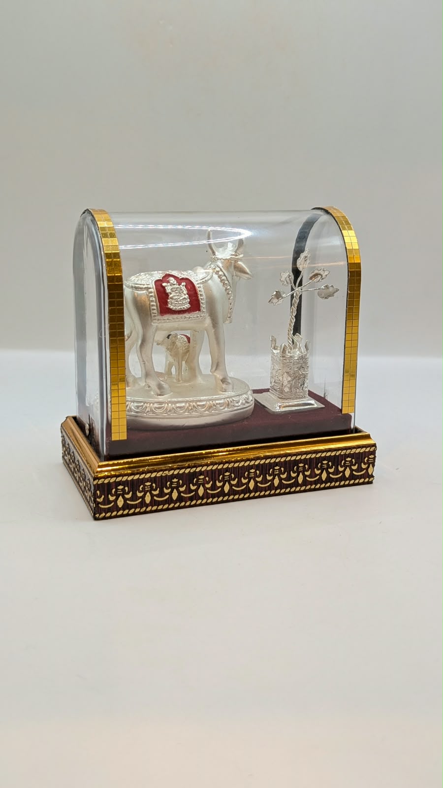 Silver Kamdhenu cow and calf in clear case, back view