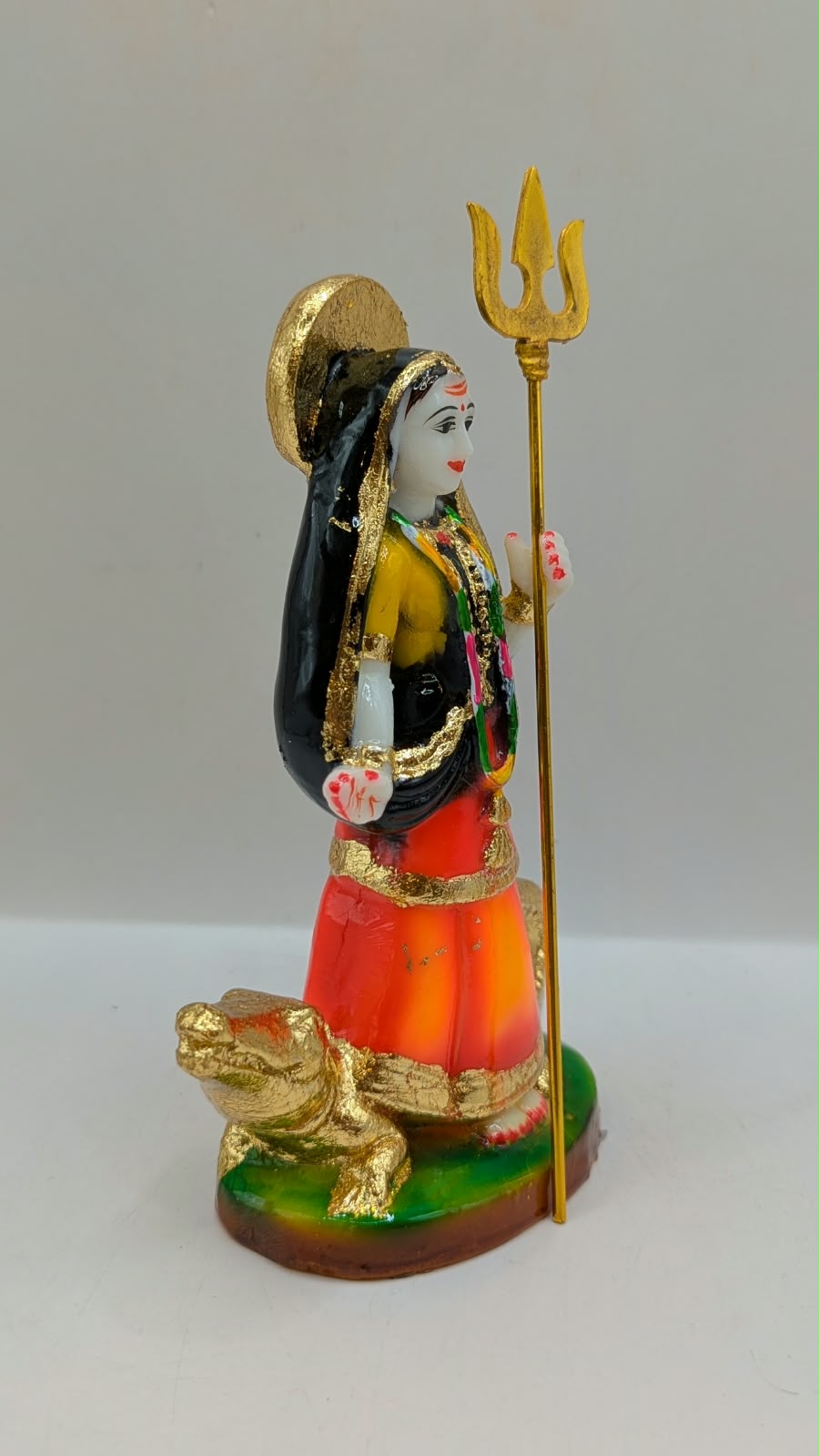 Orange and black Khodiyar Maa statue, side view