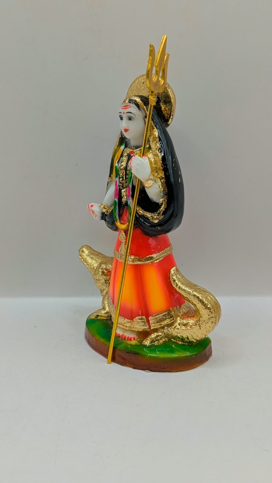 Orange and black Khodiyar Maa statue, other side view