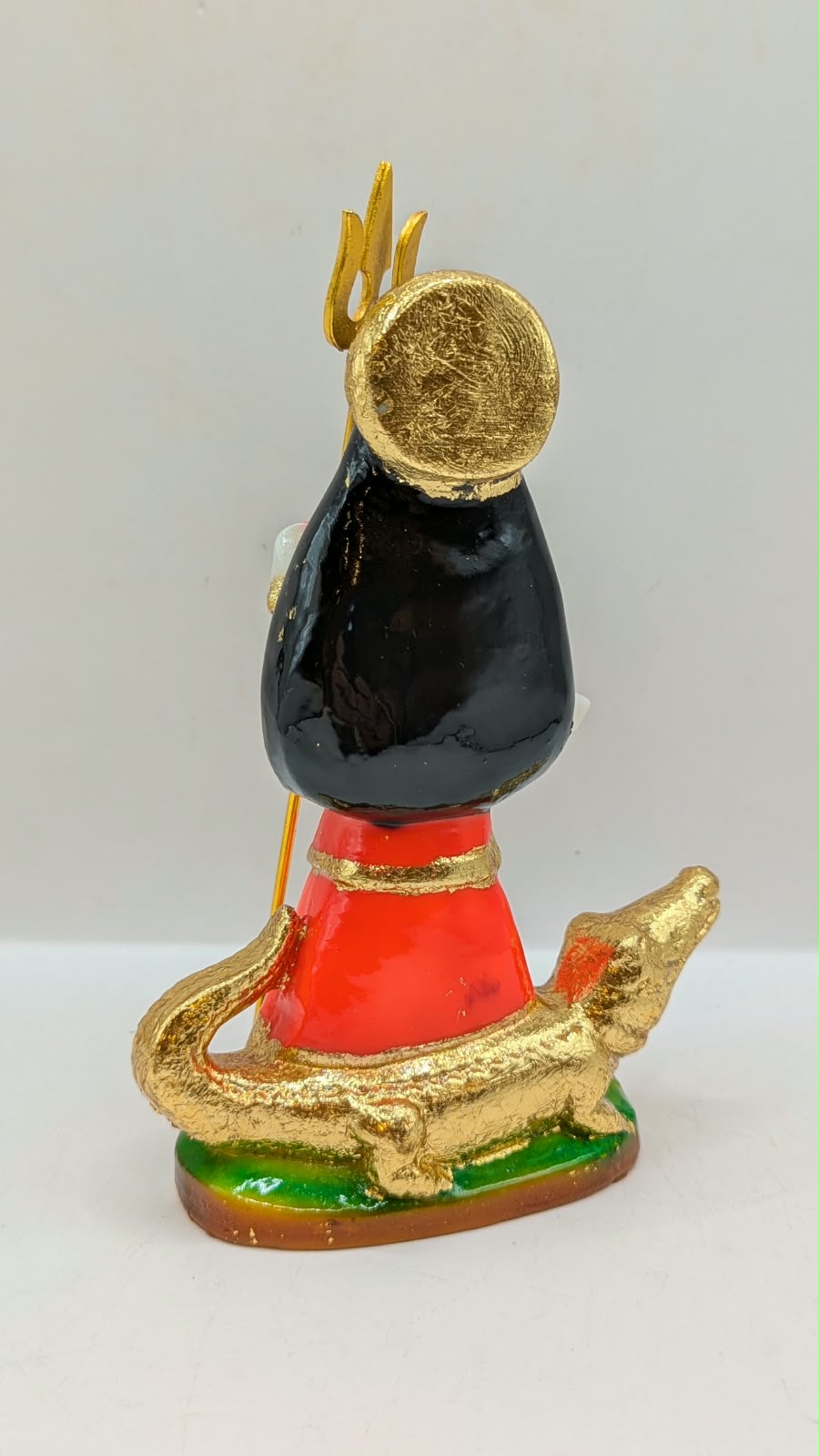 Orange and black Khodiyar Maa statue, back view